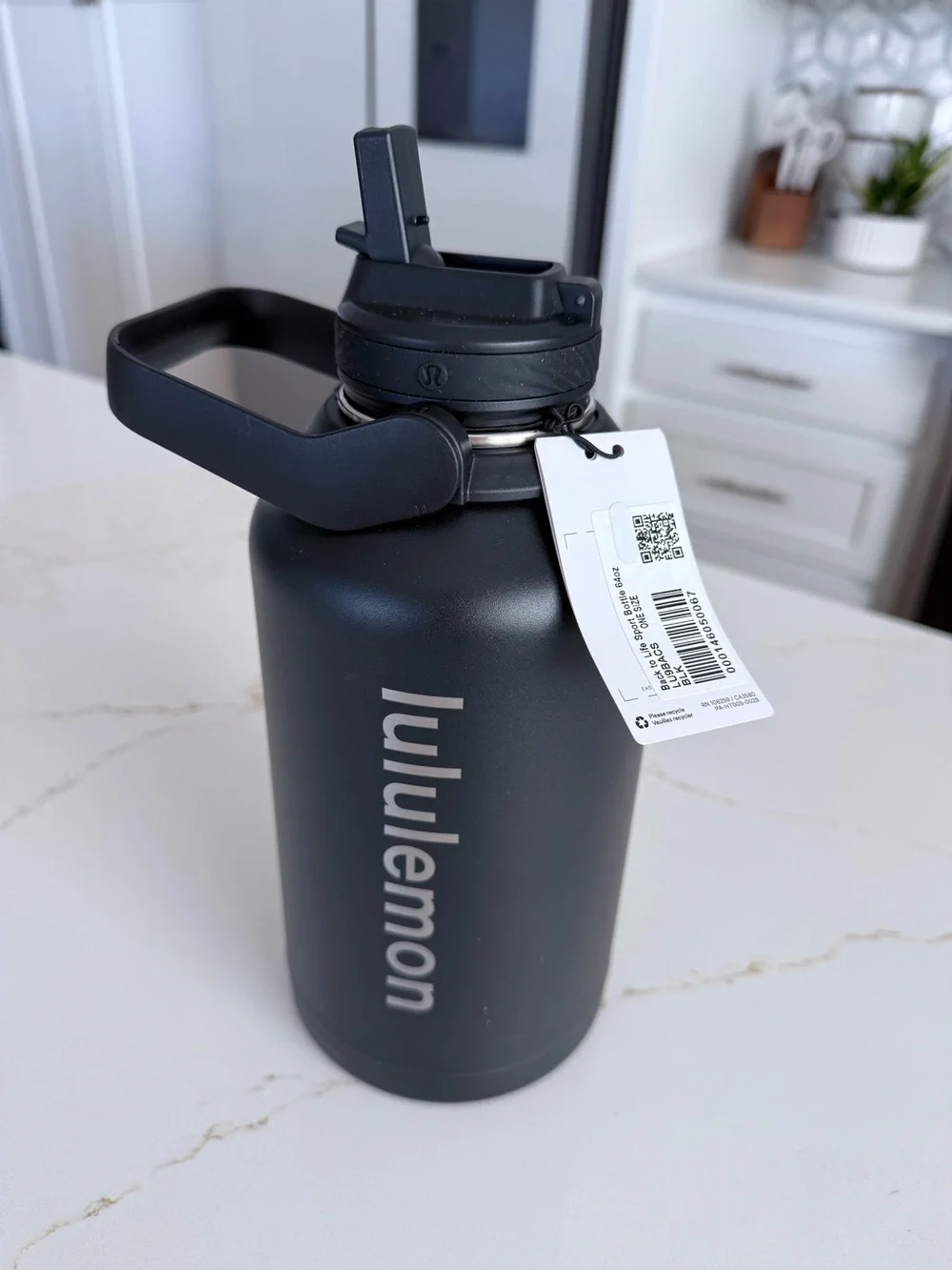Lululemon 64 Oz black insulated water bottle with a carry handle.